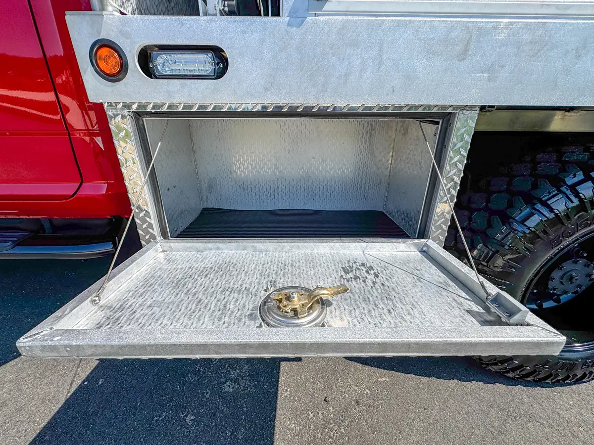 Rear-left exterior view with rear compartment open and tailboard down.